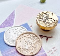 two coins sitting on top of each other next to some paper with writing on them