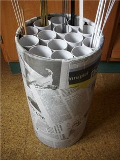 a bucket filled with lots of cups sitting on top of a counter