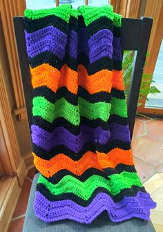 a crocheted blanket sitting on top of a chair