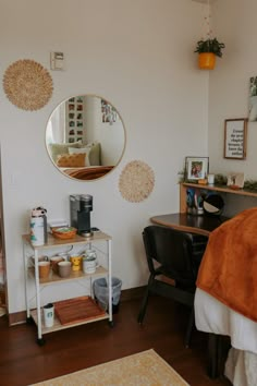 a bedroom with a bed, desk and mirror on the wall next to each other