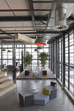 a large open room with lots of windows and furniture on the floor, in front of some stairs