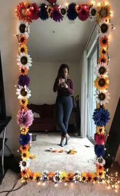 a woman taking a selfie in front of a mirror with fake flowers on it