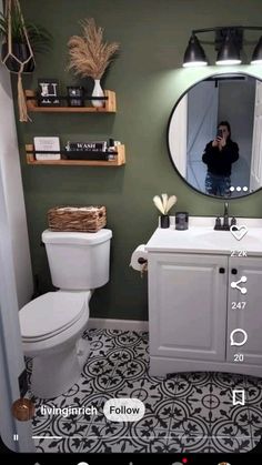 a person taking a photo in the mirror of a bathroom with black and white floor tiles