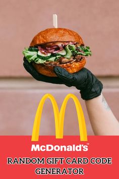 a person holding up a large hamburger with lettuce and tomato on it in front of a mcdonald's sign