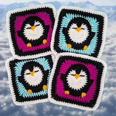 four square crocheted coasters with an image of a penguin in the center