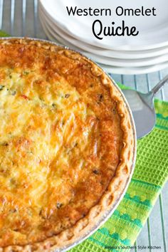 a cheesy quiche is sitting on a green napkin next to a fork