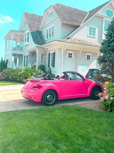 a pink convertible car parked in front of a house