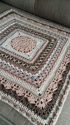 a crocheted blanket sitting on top of a couch