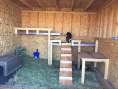 a barn filled with lots of hay next to a cat house and other animal pens