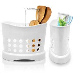 two white baskets with wooden spoons and toothbrushes in them next to each other