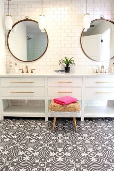 a bathroom with two sinks and mirrors on the wall, one has a pink towel in front of it