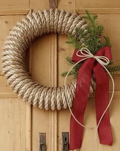 a wreath with a red bow hanging on a door