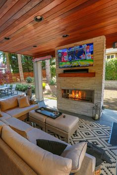 a living room with couches and a television mounted on the wall over a fire place