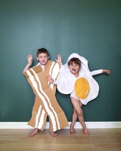 two children dressed up in costumes with an egg and bacon on their chest, standing next to each other