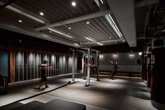 two men are playing basketball in an empty room with black and white tiles on the floor