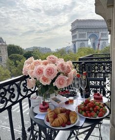 a table topped with pastries and flowers on top of a balcony