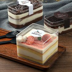 three desserts are sitting on a wooden tray