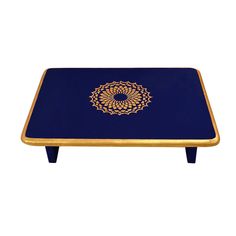 a blue and gold coffee table with an intricate design on the top, against a white background