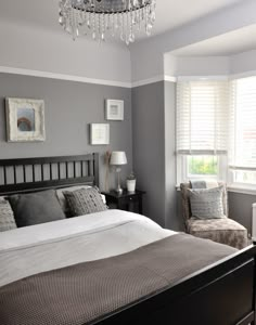 a bedroom with gray walls and white bedding