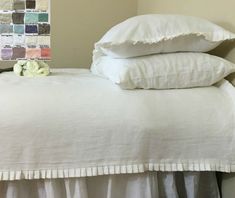 a white bed topped with pillows and blankets