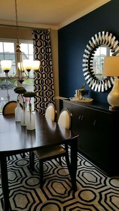 a dinning room table with chairs and a large mirror on the wall behind it