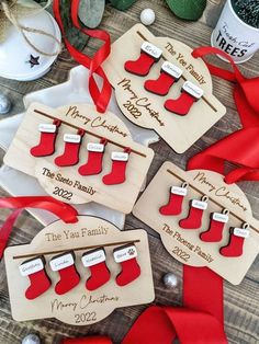 four wooden christmas stockings ornament hanging on a table with red ribbon and decorations