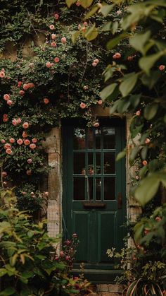 a green door surrounded by flowers and greenery