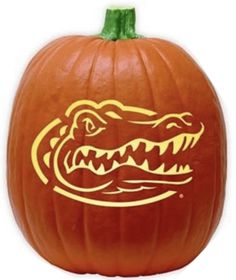 a pumpkin with an alligator's head painted on it