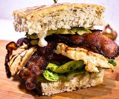 a bacon and lettuce sandwich on a wooden cutting board