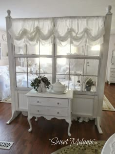 a white dresser sitting in front of a window