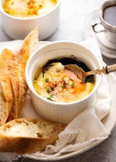 two bowls of soup and bread on a plate