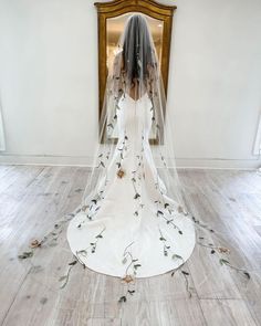 a woman in a white wedding dress with flowers on the floor and veil over her head