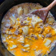 the food is being cooked in the skillet with a wooden spatula on it