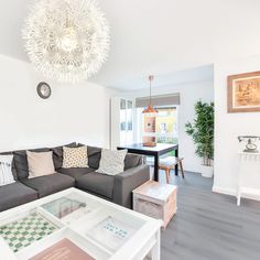 a living room filled with furniture and a large white chandelier