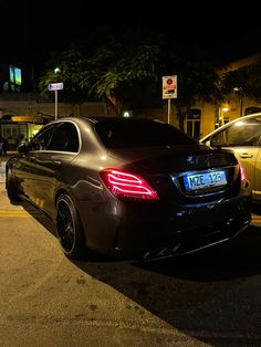 a car parked on the side of the road at night with its tail lights on