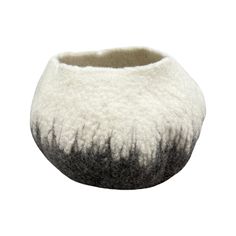 a black and white bowl with grass on the inside, sitting in front of a white background