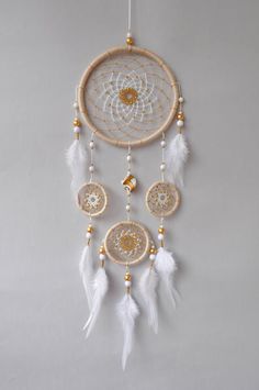 a white and gold dream catcher hanging on the wall