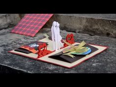 a table topped with paper and scissors on top of a stone slab next to stairs