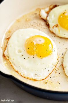 two fried eggs in a skillet on a table