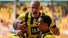 two soccer players are hugging each other in the middle of a game with yellow fans behind them