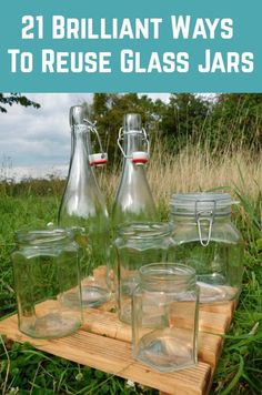 some glass jars sitting on top of a wooden crate in the grass with text overlay reading 21 brilliant ways to reuse glass jars