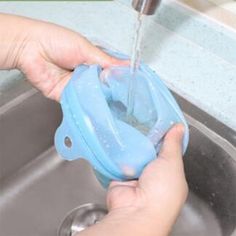 a person is washing their hands in the kitchen sink with soap on top of it