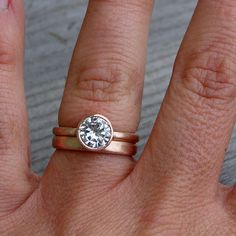 a woman's hand with a ring on it and a diamond in the middle