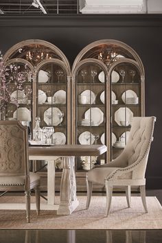 a dining room table with chairs and china cabinet