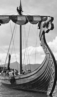 an old boat with people on it floating in the water