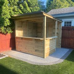 a wooden gazebo in the middle of a yard