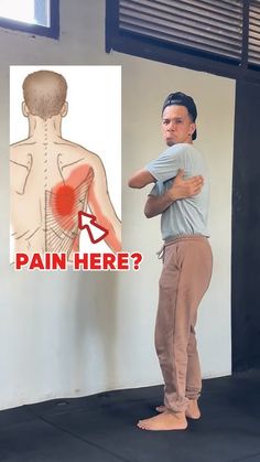 a man standing in front of a poster with an image of his back and shoulder pain