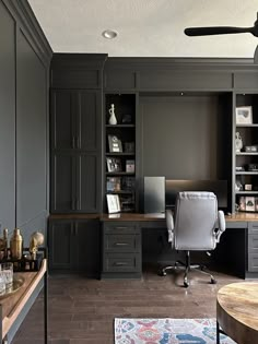 a home office with gray cabinets and wooden floors