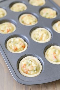 a muffin tin filled with cupcake batters on top of a wooden table