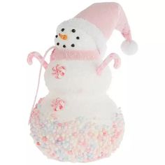 a snowman ornament with candy in it's mouth and a pink hat on top